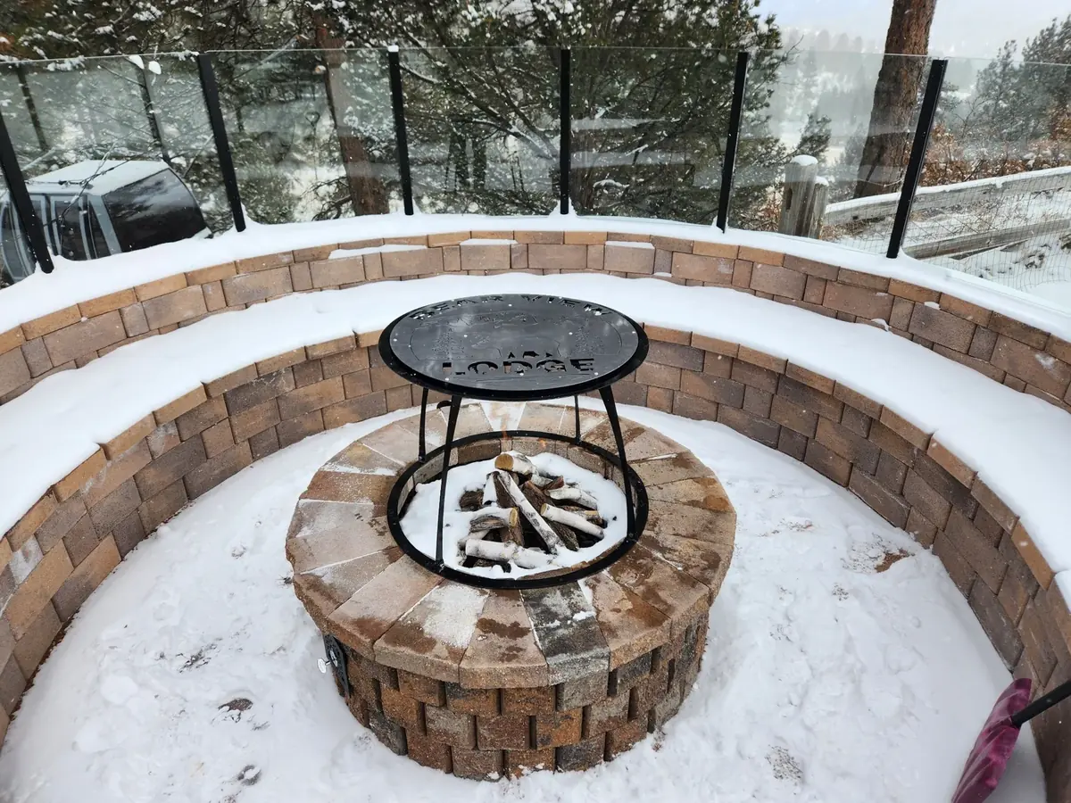 Round heat deflector installed over a snowy fire pit